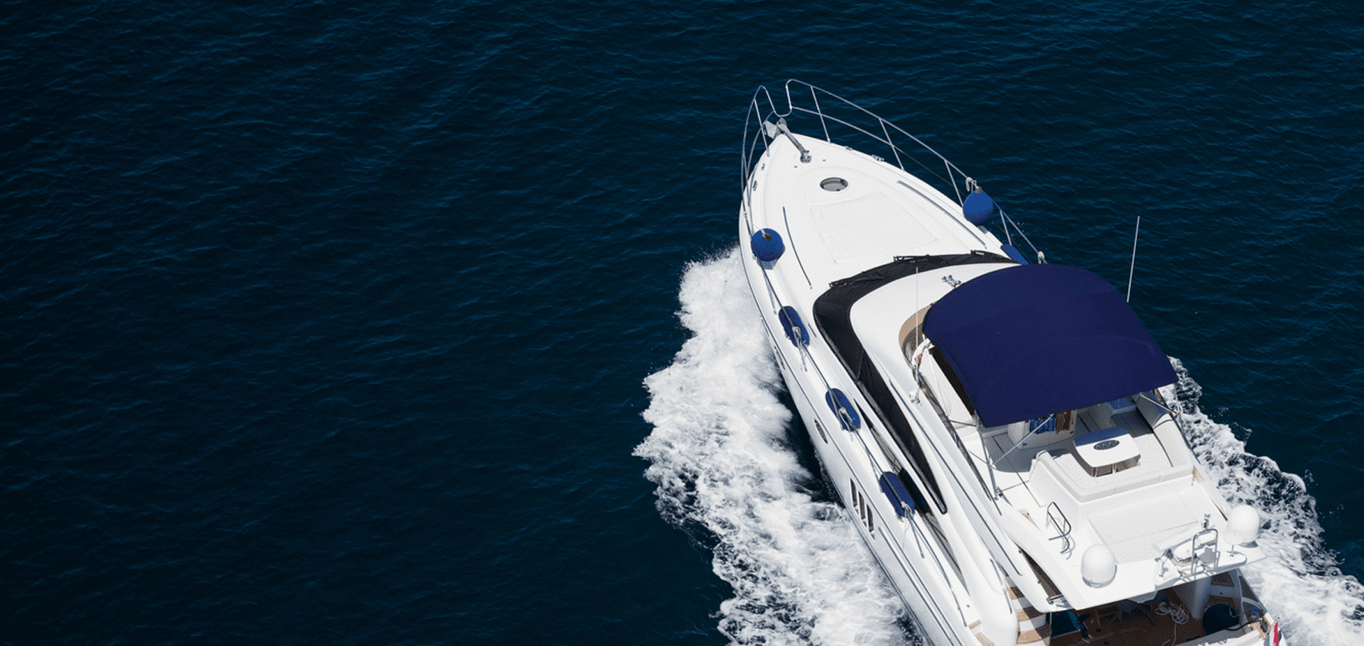 White yacht cruising on open blue water.